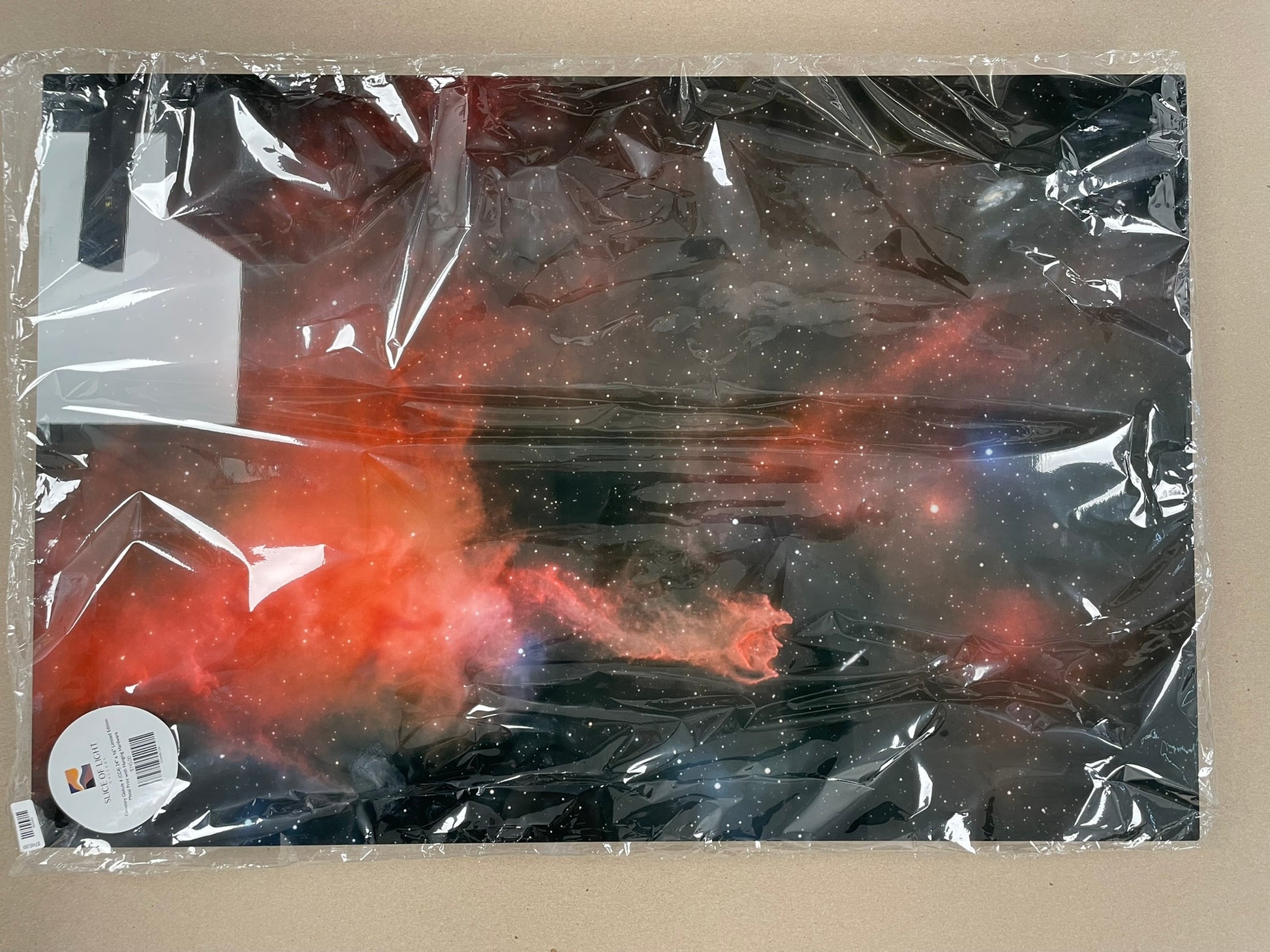 Product wrapped in clear plastic with a visible brand logo on a beige background