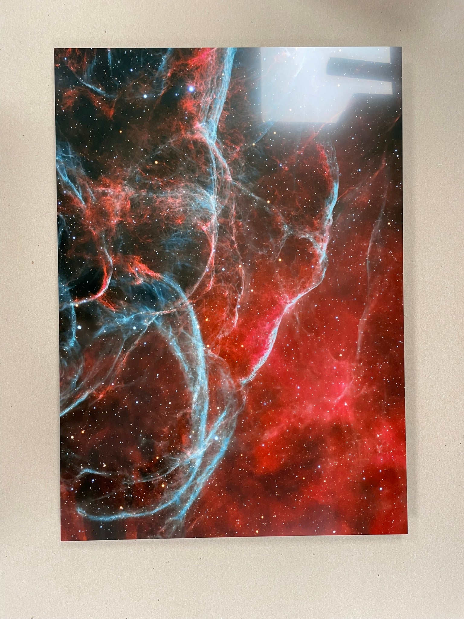 Space-themed wall art with red, blue, and black colors on a beige background