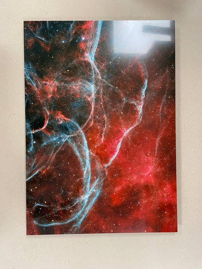 Space-themed wall art with red, blue, and black colors on a beige background