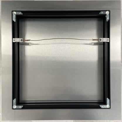 Metallic square object with a central wire on a beige background