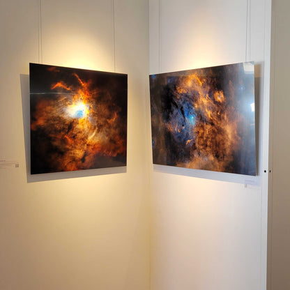 A photograph of the two metal prints titled "Passage" and "Clouds of Light and Darkness" on display in Slice of Light Gallery.