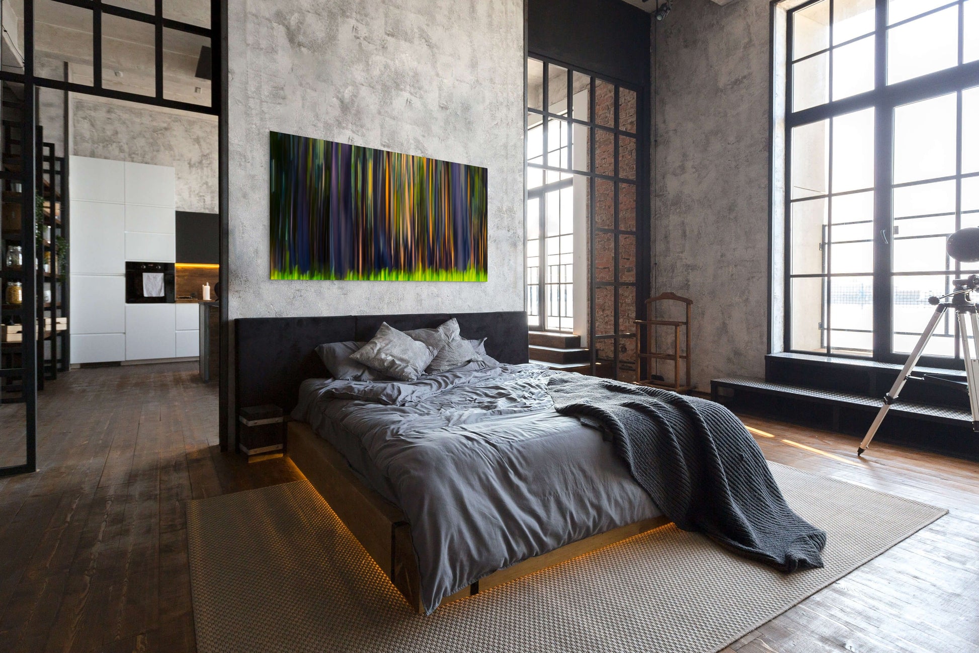 A wall art mockup featuring the photograph titled "Rainbow Eucalyptus, Big Island" by landscape photographer Ben Coffman as a 72 inch wide metal print with inset frame on display in an industrial loft apartment.