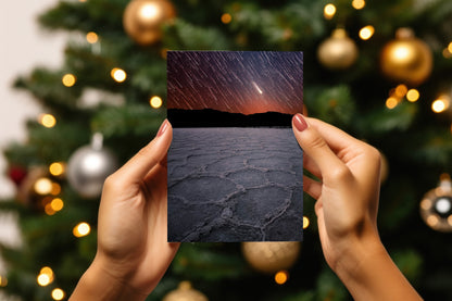 A digital mockup of a greeting card featuring the photograph titled "When Beginnings End" being held in someone's hands with christmas tree detail out of focus in the background.