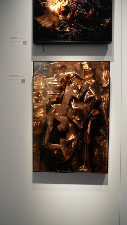 Two abstract artworks on a wall, one with metallic sheen and the other with fiery elements.