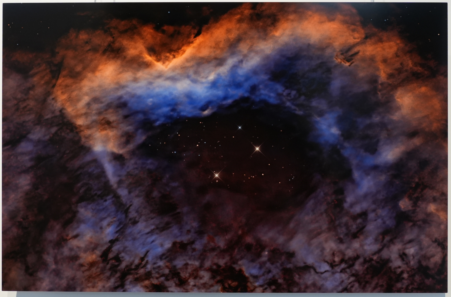 Framed photograph of a nebula on a white wall