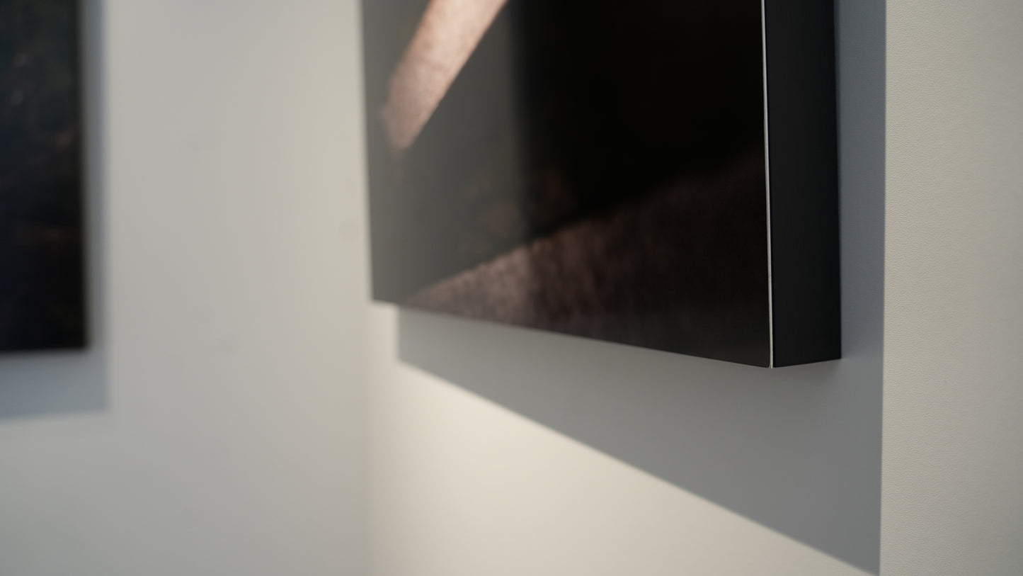 Two framed artworks on a wall with soft lighting