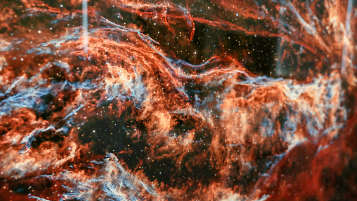 Close-up of a nebula with red and orange hues in space