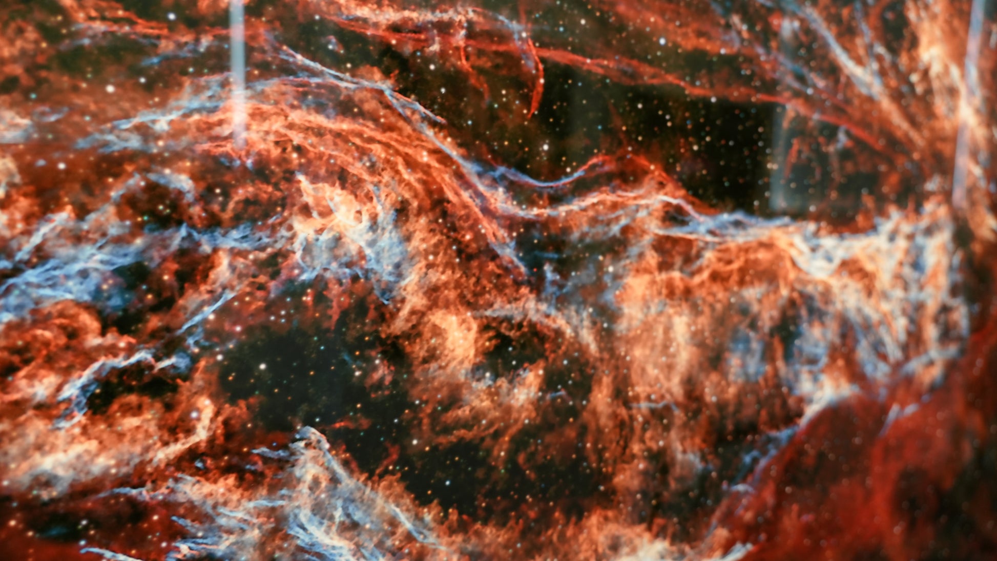 Close-up of a nebula with red and orange hues in space