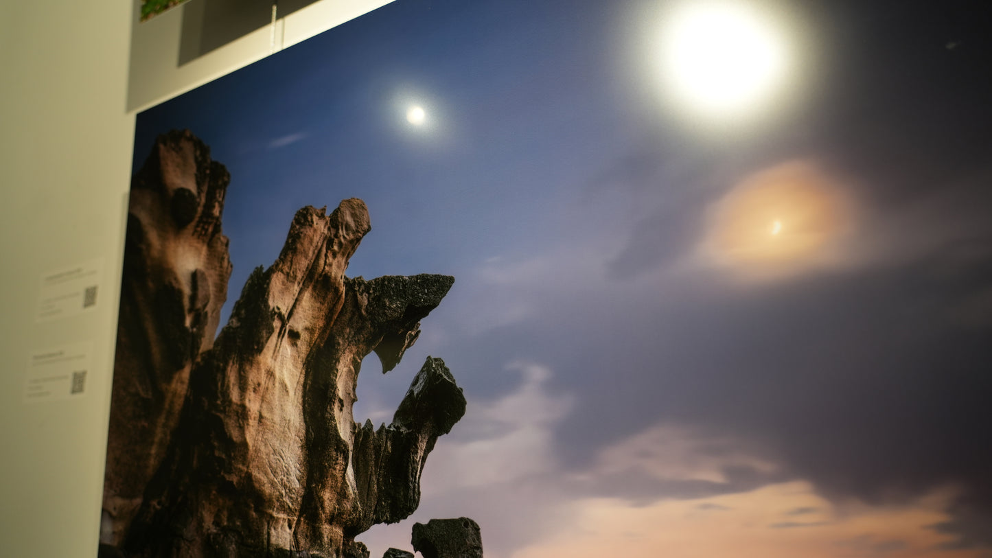 Rocks with a night sky and moonlit clouds in the background