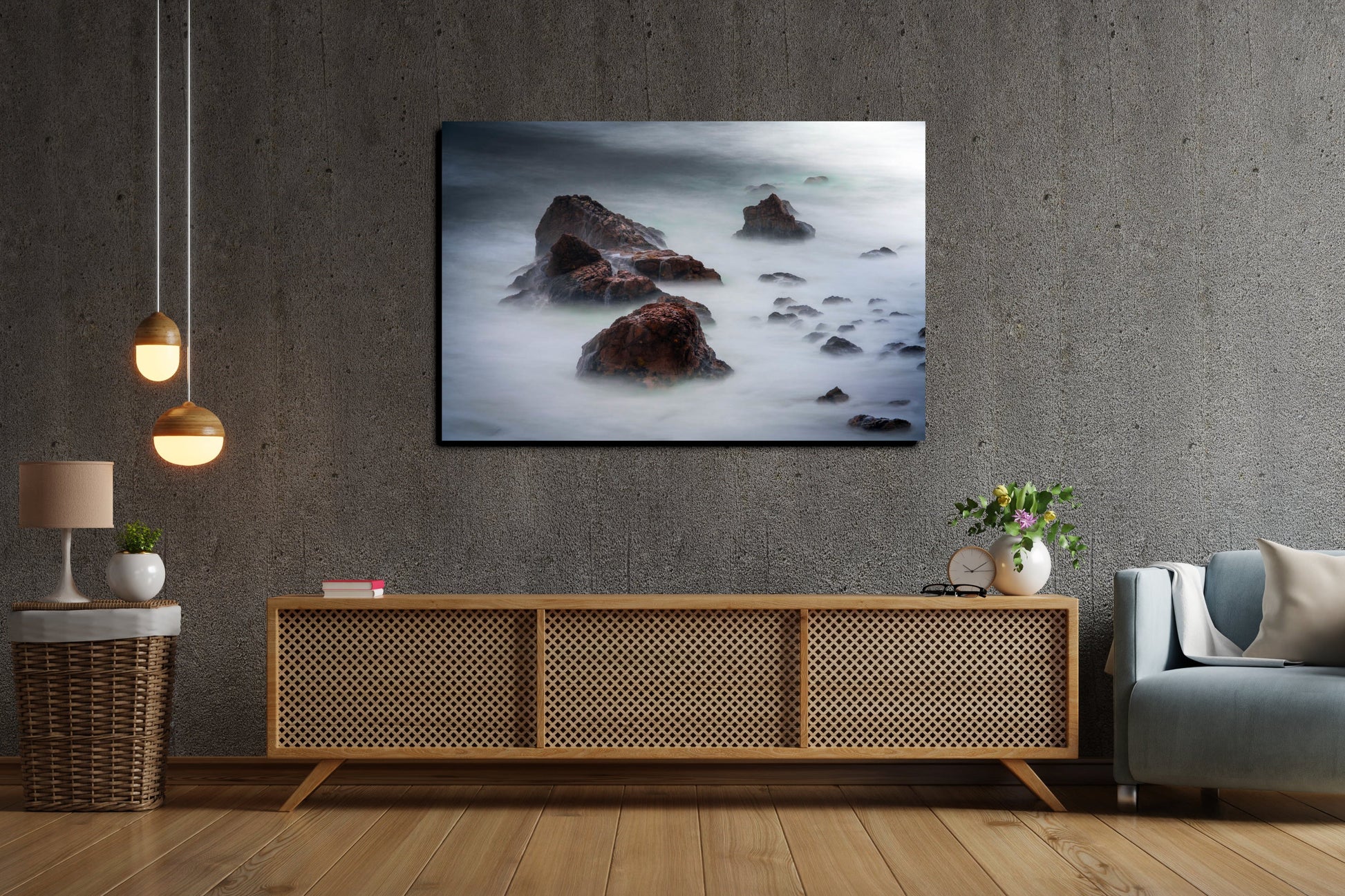 A wall art mockup featuring the metal print titled "Beyond Here Be Dragons" in an industrial themed living room with cement wall above a baby-blue club armchair and natural wood and rattan console table.