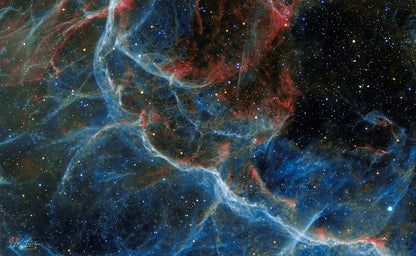 A jpg of the astrophotograph titled "Blue Vela" shot by astrophotographer J K Lovelace featuring a red and blue abstract region of the Vela Supernova Remnant.