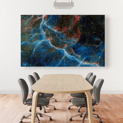A wall art mockup featuring the metal print titled "Blue Vela" displayed prominently in a large conference room with elliptical wood table gray upholstered rolling armless chairs and slat mahogany wood flooring